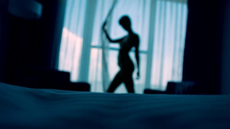 Une pièce avec, au fond, une silhouette floue représentant une travailleuse du sexe.